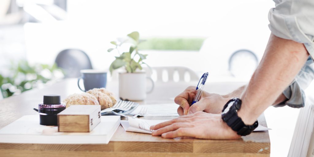 Man Writing Document Dinning Table Concept statuts